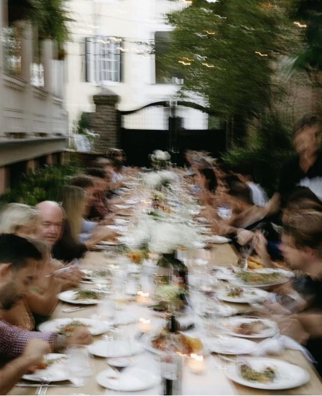 Friends and family sitting around a meal at an outdoor dinner party